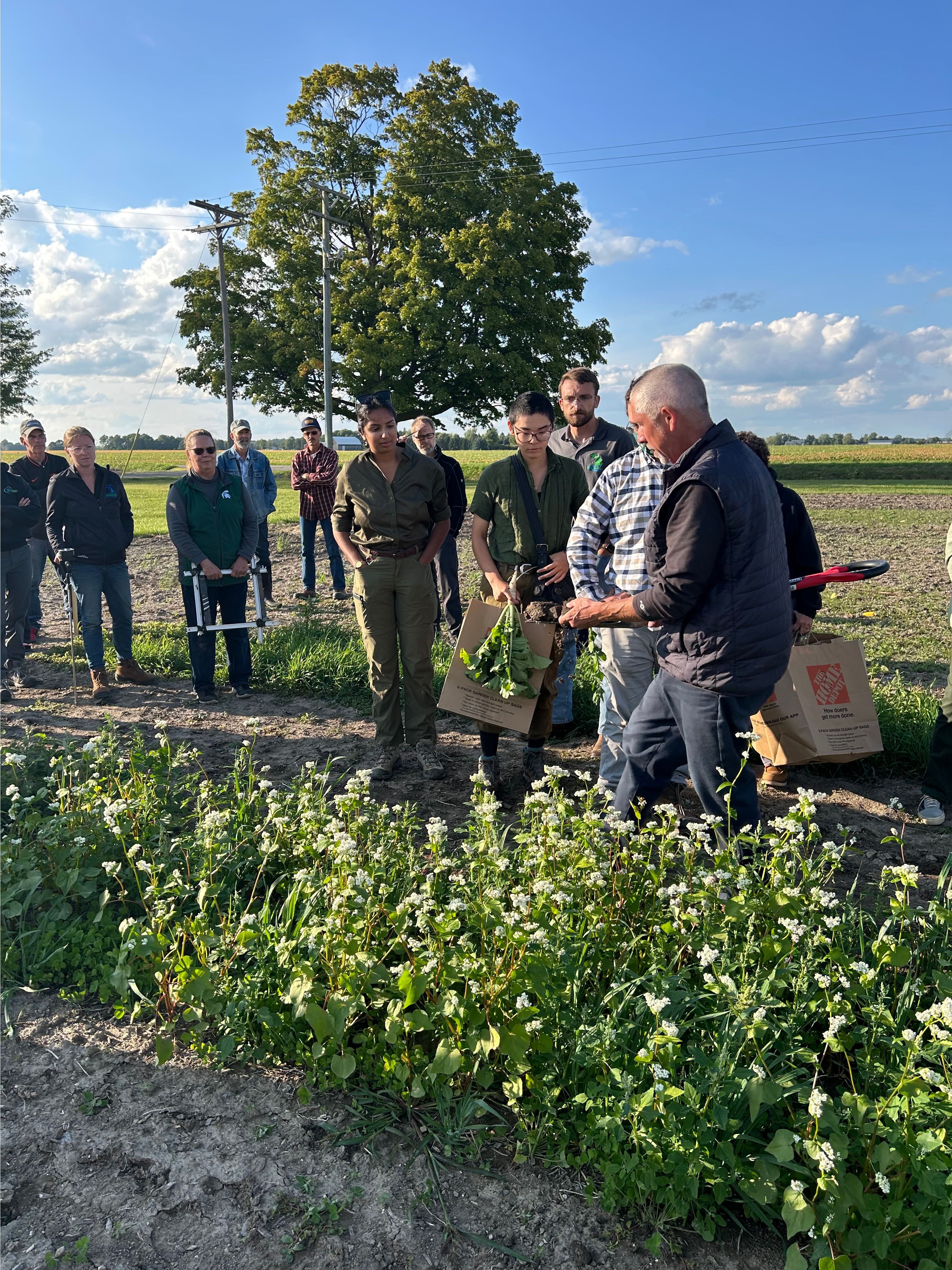 Participants stand around a field and talk with each other.